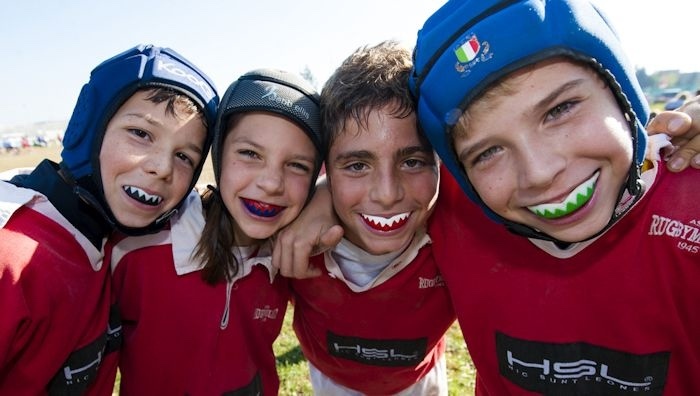 four kids playing rugby with mouthguards
